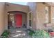 Close-up of the front entrance, showcasing a red door and decorative landscaping at 7302 E Rose Ln, Scottsdale, AZ 85250