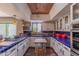 Bright kitchen features custom blue tile countertops, white cabinets, stainless appliances and rustic brick-style ceiling at 7302 E Rose Ln, Scottsdale, AZ 85250