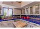 This bright kitchen is decorated with blue tile countertops and features stainless appliances and lots of counter space at 7302 E Rose Ln, Scottsdale, AZ 85250