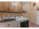 Well-lit laundry room with modern washer, dryer, storage cabinets, and neutral color scheme at 7302 E Rose Ln, Scottsdale, AZ 85250