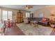 Cozy living room featuring plantation shutters, tile floors, area rug, ceiling fan and comfortable leather seating at 7302 E Rose Ln, Scottsdale, AZ 85250