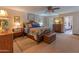 The spacious main bedroom offers a ceiling fan, bedside tables and access to a full bathroom at 7302 E Rose Ln, Scottsdale, AZ 85250
