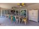 Covered patio area featuring colorful seating around a long dining table, and sliding doors to indoors at 7302 E Rose Ln, Scottsdale, AZ 85250