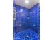Custom tiled shower featuring blue tile with decorative accents and updated fixtures at 7302 E Rose Ln, Scottsdale, AZ 85250