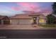 Inviting home featuring a three-car garage, tile roof, and professionally landscaped yard at 7344 E Flower Ave, Mesa, AZ 85208