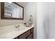 Cozy half bathroom with a modern vanity, a framed mirror, and stylish towel arrangement at 811 E Eugie Ave, Phoenix, AZ 85022