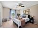 Cozy bedroom with a ceiling fan, a comfortable queen-size bed, and a large window offering natural light at 811 E Eugie Ave, Phoenix, AZ 85022