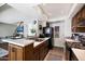 Well-lit kitchen features an island, a stainless steel sink, and sleek appliances, with an adjacent living room area at 811 E Eugie Ave, Phoenix, AZ 85022