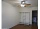 A bedroom with wood floors, ceiling fan, and open closet leading to a laundry room at 8334 N 55Th Ave, Glendale, AZ 85302