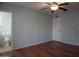 Bright bedroom with wood floors, ceiling fan, and a view of an ensuite bathroom at 8334 N 55Th Ave, Glendale, AZ 85302