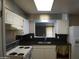 Cozy kitchen with white cabinets, black countertops, and stainless steel sink at 8334 N 55Th Ave, Glendale, AZ 85302
