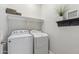 Bright laundry room featuring a white washer and dryer, complemented by a shelf and decorative accents at 897 E Cherry Hills Dr, Chandler, AZ 85249