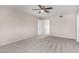 Spacious bedroom with neutral walls and carpet, with ceiling fan and an open doorway at 9803 N 40Th Dr, Phoenix, AZ 85051