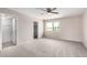 Bright bedroom with neutral walls and carpet, fan, and window overlooking outdoor trees and sky at 9803 N 40Th Dr, Phoenix, AZ 85051