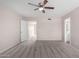 Bright bedroom with neutral walls and carpet, with ceiling fan and an open doorway to bathroom at 9803 N 40Th Dr, Phoenix, AZ 85051
