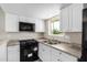 Well-lit kitchen boasting white cabinetry and modern black appliances at 9803 N 40Th Dr, Phoenix, AZ 85051