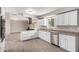 Bright kitchen features white cabinetry, stainless appliances, and an island gas cooktop with range hood at 9803 N 40Th Dr, Phoenix, AZ 85051