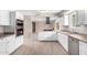 Bright kitchen features white cabinetry, stainless appliances, and an island gas cooktop with range hood at 9803 N 40Th Dr, Phoenix, AZ 85051