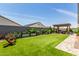 Large backyard featuring a paved walkway, artificial grass, raised garden beds and a cozy pergola at 10447 W Salter Dr, Peoria, AZ 85382