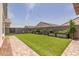 Well-maintained backyard with artificial grass, decorative wall art, and flourishing planter boxes at 10447 W Salter Dr, Peoria, AZ 85382