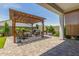 Inviting backyard patio with wooden pergola, plush seating, grill and verdant landscaping at 10447 W Salter Dr, Peoria, AZ 85382