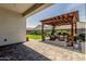 Relaxing backyard featuring a cozy patio with a pergola, complemented by lush green grass and landscaping at 10447 W Salter Dr, Peoria, AZ 85382