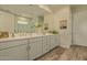 Elegant bathroom with dual sinks, white cabinetry, a large mirror, and a glass-enclosed shower at 10447 W Salter Dr, Peoria, AZ 85382