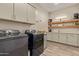 Efficient laundry room with modern washer and dryer, plenty of storage, sink and counter space at 10447 W Salter Dr, Peoria, AZ 85382