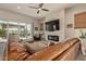 Spacious living room with a stone fireplace, ceiling fan, and sliding glass door to the patio at 10447 W Salter Dr, Peoria, AZ 85382