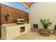 Outdoor kitchen featuring a pizza oven, stone counter, and wood-burning stove, perfect for entertaining at 10447 W Salter Dr, Peoria, AZ 85382