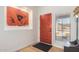 Welcoming foyer with a bright orange front door, neutral walls, a side window, and light hardwood floors at 13918 N 78Th Ave, Peoria, AZ 85381
