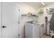Bright laundry room features front-load washer and dryer with wire shelving for storage at 13918 N 78Th Ave, Peoria, AZ 85381