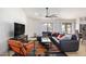 Bright living room with an orange accent chair and a large grey sectional sofa and ceiling fan at 13918 N 78Th Ave, Peoria, AZ 85381