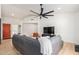 Cozy living room featuring a black leather couch, a ceiling fan, and views into the adjacent kitchen at 13918 N 78Th Ave, Peoria, AZ 85381