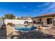 Beautiful in-ground pool with desert landscaping, waterfall feature, and lounge chairs under an umbrella at 13918 N 78Th Ave, Peoria, AZ 85381