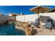 Private pool area with rock waterfall feature and patio chairs shaded by an umbrella at 13918 N 78Th Ave, Peoria, AZ 85381