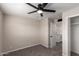 Neutral bedroom featuring a ceiling fan, carpet, and a view into the bathroom at 143 W Ray Rd, Chandler, AZ 85225