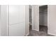 Hallway view with carpet flooring, neutral walls, and access to bathroom and closet at 143 W Ray Rd, Chandler, AZ 85225
