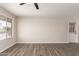 Bright, empty living room featuring wood-look tile flooring and a ceiling fan at 143 W Ray Rd, Chandler, AZ 85225
