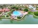 Stunning aerial view of a community with a sandy beach pool, lush landscaping, and serene waterways at 1502 E Treasure Cove Dr, Gilbert, AZ 85234