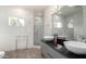 Modern bathroom with double sinks, glass shower, white marble tile, and a bright window at 1502 E Treasure Cove Dr, Gilbert, AZ 85234