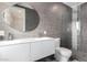 Gray tiled bathroom features a large mirror, double sinks, and a spacious glass-enclosed shower at 1502 E Treasure Cove Dr, Gilbert, AZ 85234