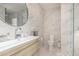 Bright bathroom featuring marble tiling, a floating vanity and a large, round mirror at 1502 E Treasure Cove Dr, Gilbert, AZ 85234