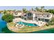 Striking waterfront home featuring a sparkling pool, lush landscaping, and expansive patio area at 1502 E Treasure Cove Dr, Gilbert, AZ 85234