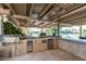 Well-appointed outdoor kitchen with grill, sink, refrigerator, and bar area with lake views at 1502 E Treasure Cove Dr, Gilbert, AZ 85234