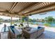 Luxurious covered outdoor living space offering comfortable seating, a fire pit, and lake views at 1502 E Treasure Cove Dr, Gilbert, AZ 85234