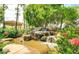 Beautiful backyard with a rock waterfall and lush landscaping, creating a serene outdoor retreat at 1502 E Treasure Cove Dr, Gilbert, AZ 85234