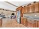Kitchen with stainless steel refrigerator, wood cabinets, granite countertops, and an open view of living area at 15226 N 51St St, Scottsdale, AZ 85254
