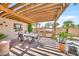 Covered patio with outdoor kitchen, table, chairs, string lights, and desert landscaping at 15226 N 51St St, Scottsdale, AZ 85254