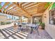 Covered patio with wooden pergola, an outdoor table and chairs, and desert landscaping at 15226 N 51St St, Scottsdale, AZ 85254